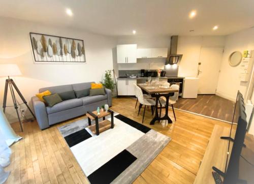 un salon avec un canapé et une table dans l'établissement Le Général - 4 personnes - Poitiers - La Conciergerie, à Poitiers