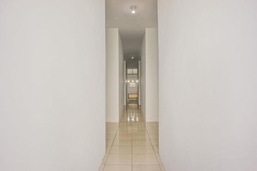 un couloir avec colonnes blanches dans un bâtiment dans l'établissement OYO 93306 Penginapan Permata Hijau Syariah, à Parepare