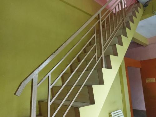 - un escalier en bois dans une chambre aux murs verts dans l'établissement OYO 93306 Penginapan Permata Hijau Syariah, à Parepare