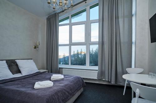a bedroom with a bed and a large window at Diamant Dragobrat in Dragobrat