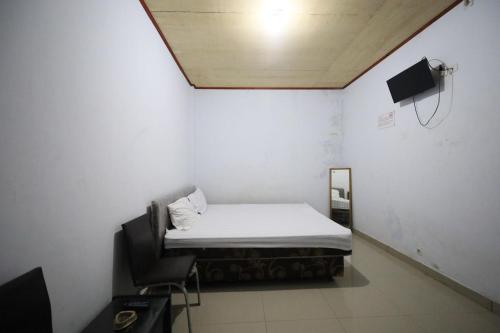 Habitación pequeña con cama y espejo. en OYO 93306 Kos Citra Syariah, en Parepare