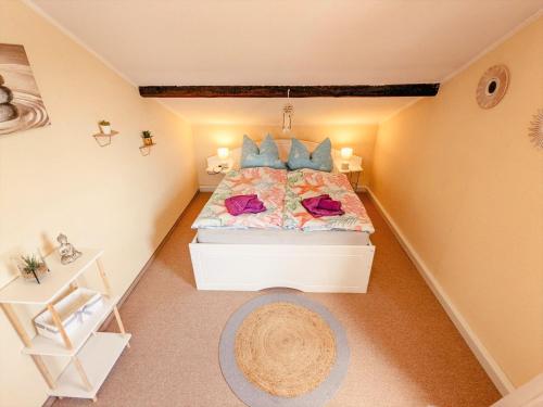 a small attic bedroom with a bed with blue pillows at W3 - Urlaubsmagie - Maisonette-Wohnung mit Pool in Lichtenhain