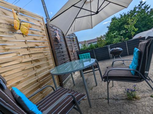 a patio with a table and two chairs and an umbrella at W3 - Urlaubsmagie - Maisonette-Wohnung mit Pool in Lichtenhain