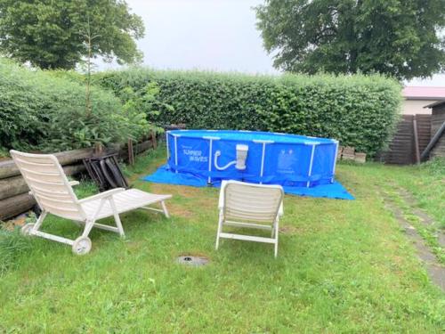 two chairs sitting in the grass in a yard at W3 - Urlaubsmagie - Maisonette-Wohnung mit Pool in Lichtenhain