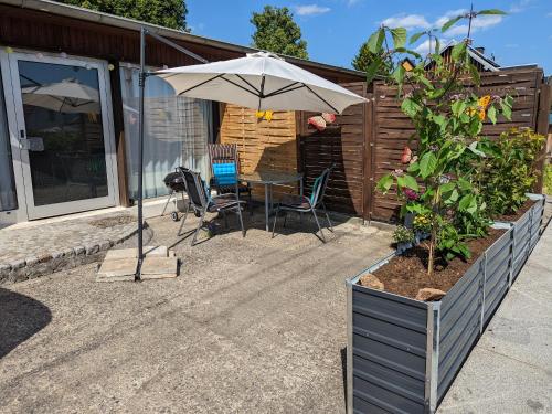 a patio with an umbrella and a table and chairs at W3 - Urlaubsmagie - Maisonette-Wohnung mit Pool in Lichtenhain