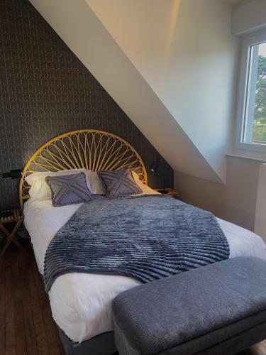 une chambre avec un grand lit avec une tête de lit en bois dans l'établissement Villa des Pins, à Jullouville