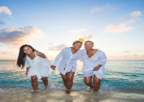 a group of people dressed in white walking on the beach at Sombre 14-E in Santa Cruz