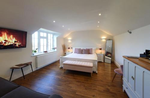 a bedroom with a white bed and a fireplace at Hilltop Country House in Macclesfield