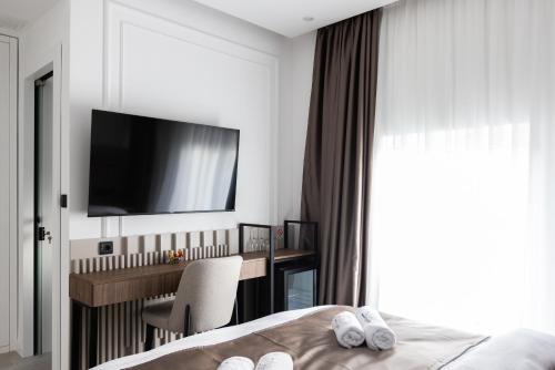 a bedroom with a bed and a desk and a television at RIVA sleep & chill in Valjevo