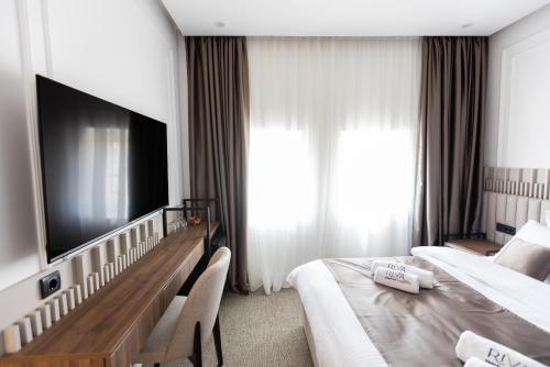 a hotel room with two beds and a flat screen tv at RIVA sleep & chill in Valjevo