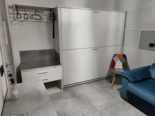 eine Küche mit einem weißen Kühlschrank und einer blauen Couch in der Unterkunft Lagrange 23 in Cambiano