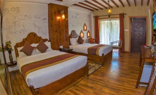a bedroom with two beds in a room at Hotel Jungle Crown in Sauraha