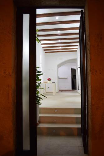uma porta aberta para um quarto com uma cama e uma mesa em La Dimora Di Garibaldi em Augusta