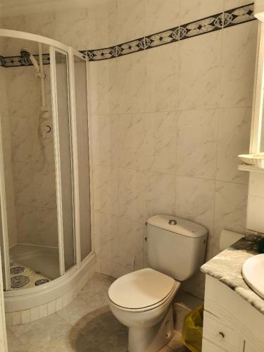 a white bathroom with a toilet and a shower at Luxury Studio Apartment in Torrox Costa