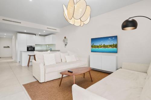 a living room with white furniture and a tv on the wall at Stunning Apt in Mijas by Costarentals - Ref 235 in Mijas Costa