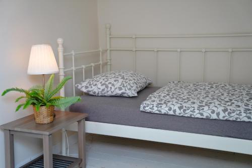 a bedroom with a bed and a table with a plant at De Koetsier in Lanaken