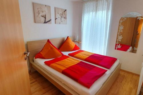 een bed met kleurrijke dekens en kussens in een kamer bij Strandkorb in Borkum