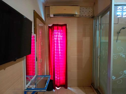 een badkamer met rode gordijnen in een kamer bij OYO 93278 Wisma Syariah Lahundape in Kendari