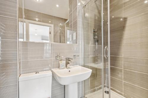 y baño blanco con lavabo y ducha. en Cozy Central London Residence Stockwell, en Londres