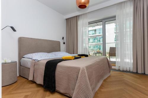 sypialnia z łóżkiem i dużym oknem w obiekcie Yacht Park Marina w mieście Gdynia