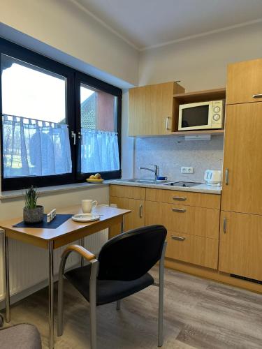 a kitchen with a table and a chair and a microwave at Apartment Schorre in Löhne