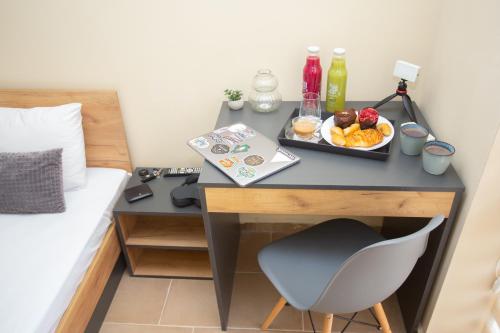 a desk with a plate of fruit on it next to a bed at Veliko Turnovo Studios - Stylish & Convenient in Veliko Tŭrnovo