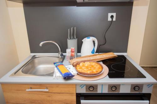 a kitchen counter with a sink and a bowl of food at Veliko Turnovo Studios - Trendy & Convenient in Veliko Tŭrnovo