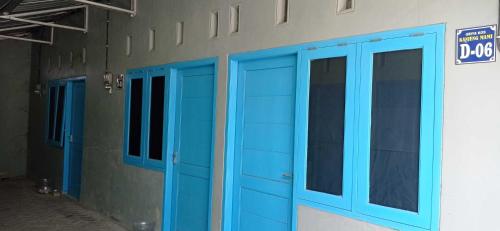 uma fila de portas azuis no lado de um edifício em SPOT ON 93210 Griya Kos Kanjeng Mami Syariah em Jombang