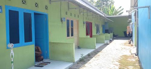 uma fileira de casas com portas coloridas sobre eles em SPOT ON 93210 Griya Kos Kanjeng Mami Syariah em Jombang