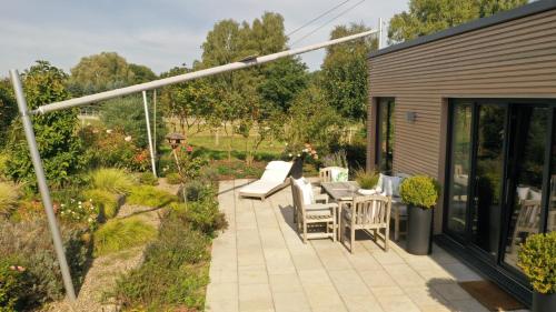 a patio with chairs and tables in a garden at Deine Genuss-Auszeit in Asendorf