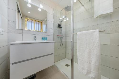 a white bathroom with a sink and a shower at Salou apartment beach in Salou