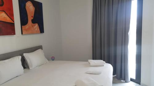 a bedroom with a white bed and a painting at Hypnos Residence in Nicosia