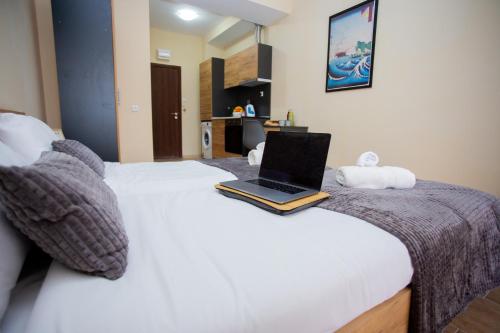 a laptop computer sitting on top of a bed at Trendy Studios with FREE PARKING in Veliko Turnovo in Veliko Tŭrnovo