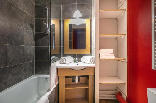a bathroom with a sink and a bath tub at Résidence Pierre & Vacances L'Ours Blanc in L'Alpe-d'Huez