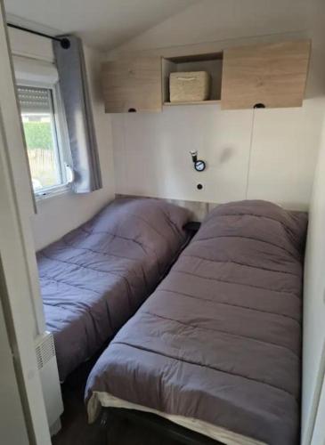 - une chambre avec 2 lits dans une petite maison dans l'établissement MOBIL-HOME 3 CHAMBRES LA TESTE DE BUCH, à La Teste-de-Buch