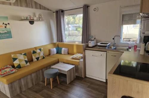 a living room with a couch and a kitchen at MOBIL-HOME 3 CHAMBRES LA TESTE DE BUCH in La Teste-de-Buch