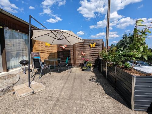 a patio with an umbrella and a table and chairs at W3 - Urlaubsmagie - Maisonette-Wohnung mit Pool in Lichtenhain