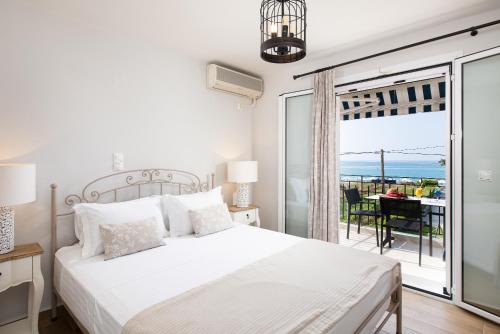 une chambre blanche avec un lit et un balcon dans l'établissement Barefoot Contessa, à Lourdhata