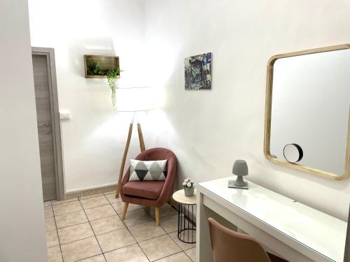 La salle de bains est pourvue d'une chaise et d'un miroir. dans l'établissement La Badessa Home, à Naples