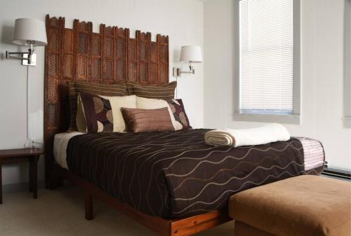 a bedroom with a large bed with a wooden headboard at Panther Mountain Lodge in Phoenicia