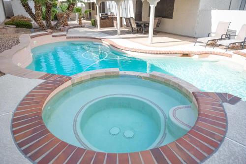 une grande piscine entourée d'un chemin en briques. dans l'établissement Delightful 4 Bedroom House with Pool!, à Las Vegas