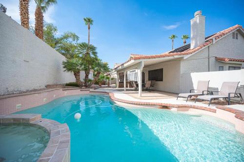 a swimming pool in front of a house at Delightful 4 Bedroom House with Pool! in Las Vegas