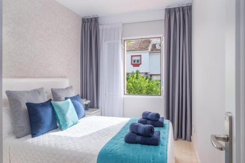 Un dormitorio con una cama con toallas azules. en Luxury DelMare Marbella Pool Family Only, en Marbella