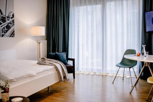 a bedroom with a bed and a chair and a table at THE FLAG München M. in Munich