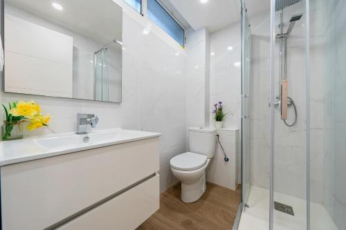 een witte badkamer met een toilet en een douche bij Apartamento junto al mar en salou in Salou