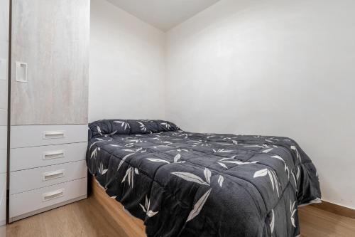 een witte slaapkamer met een bed en een dressoir bij Apartamento junto al mar en salou in Salou