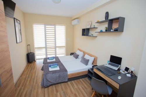 a small room with a bed and a desk with a computer at Veliko Turnovo Studios - Stylish & Convenient in Veliko Tŭrnovo