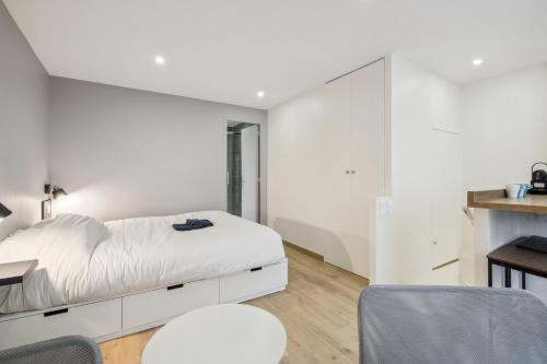 a bedroom with a white bed and a desk at La Pépite de Bastille in Paris