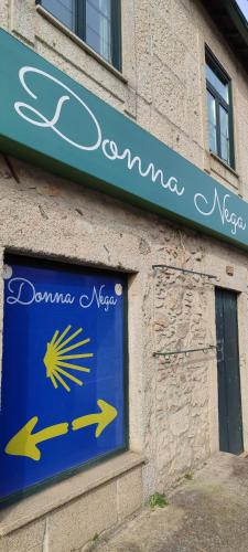 a blue sign on the side of a building at Donna Nega Guest House in Caminha