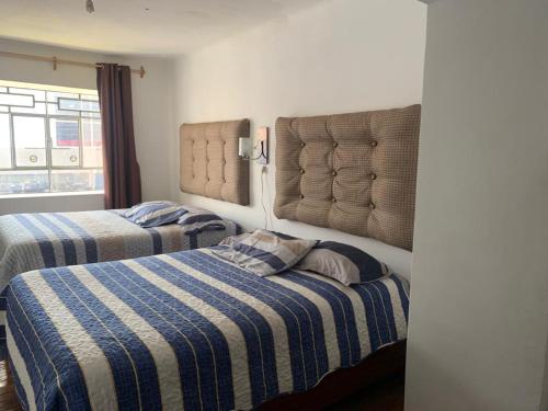 a bedroom with two beds and a window at IAN TRAVEL in Cusco